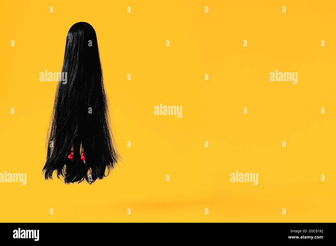 Long hair female ghost with red high heel shoe flying to the air with orange background. Minimal Halloween scary concept. Stock Photo