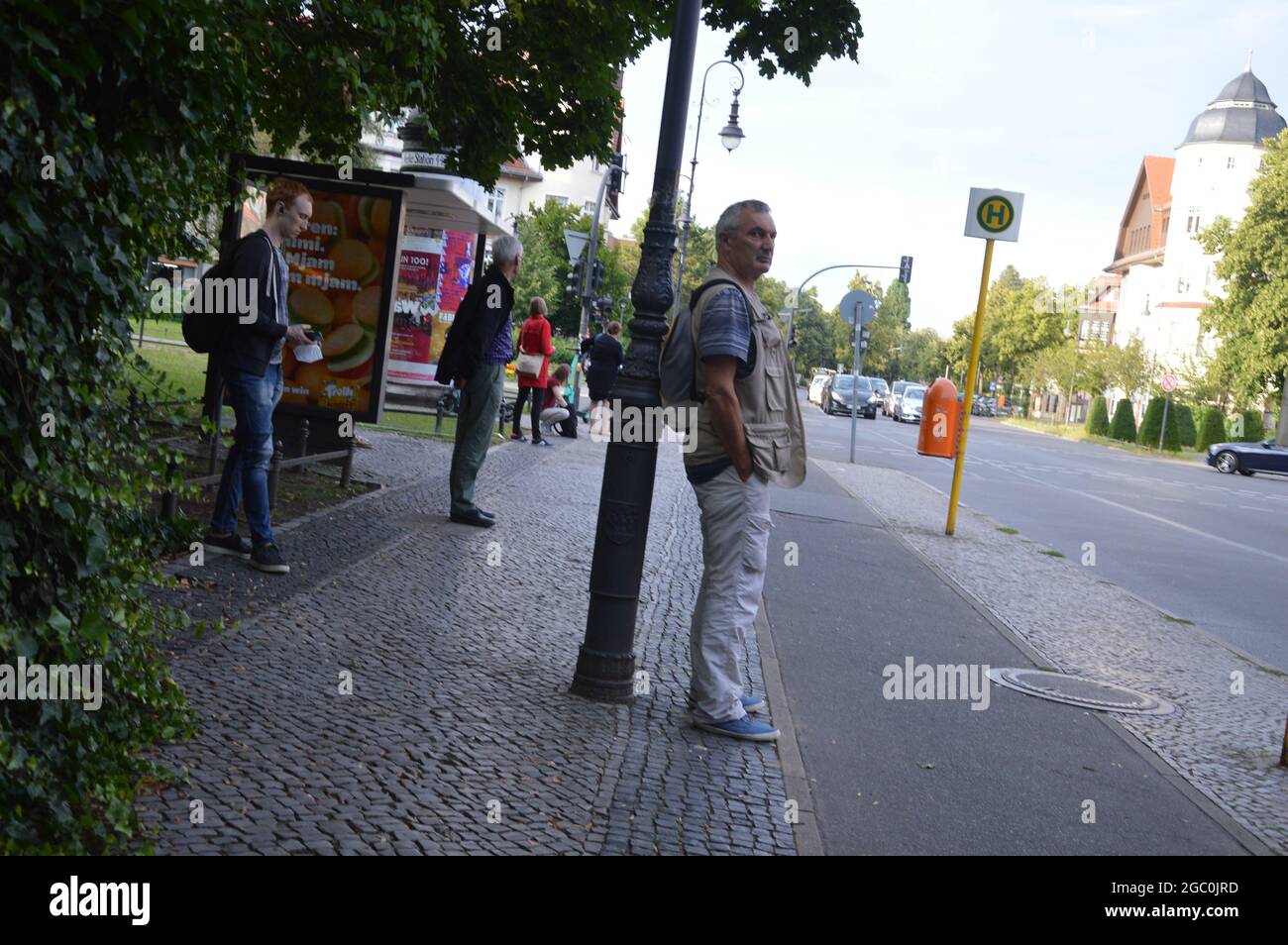 Waiting for the bus at bus stop in the evening at Lindenthaler Allee, Mexikoplatz, in Zehlendorf, Berlin, Germany - August 4, 2021. Stock Photo