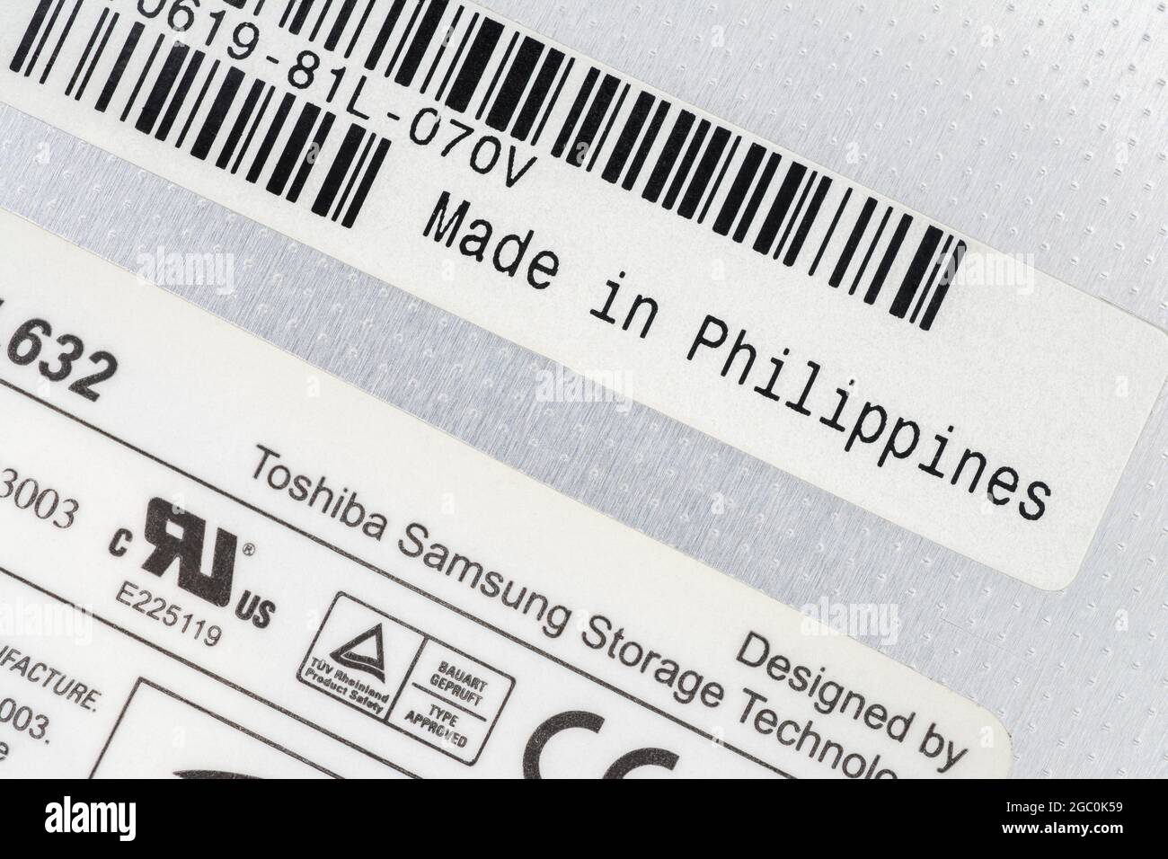 Paper labels on the back of a Toshiba-Samsung made removable laptop DVD Writer unit with made in the Philippines label. For offshoring parts. Stock Photo