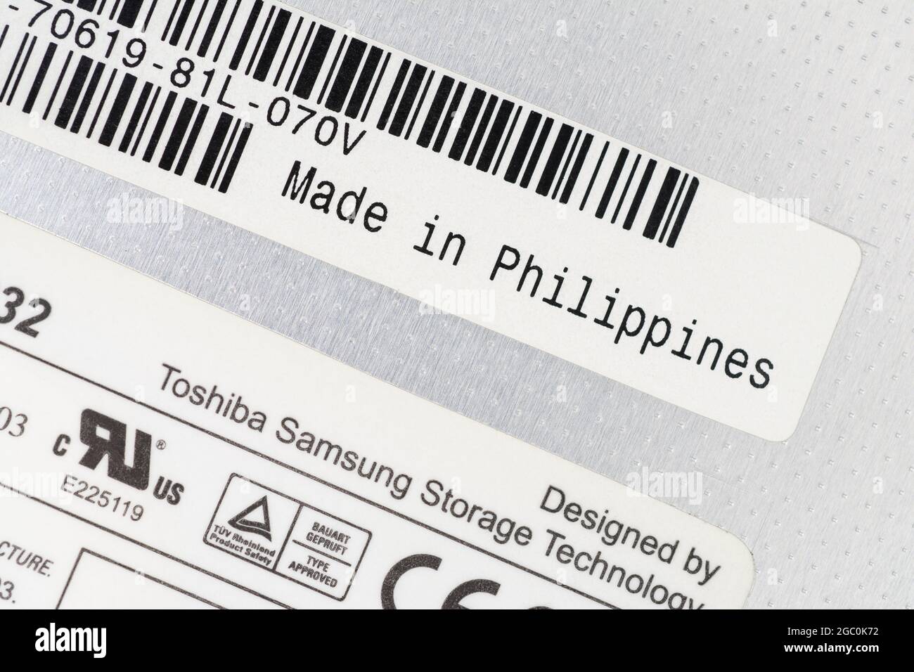 Paper labels on the back of a Toshiba-Samsung made removable laptop DVD Writer unit with made in the Philippines label. For offshoring parts. Stock Photo
