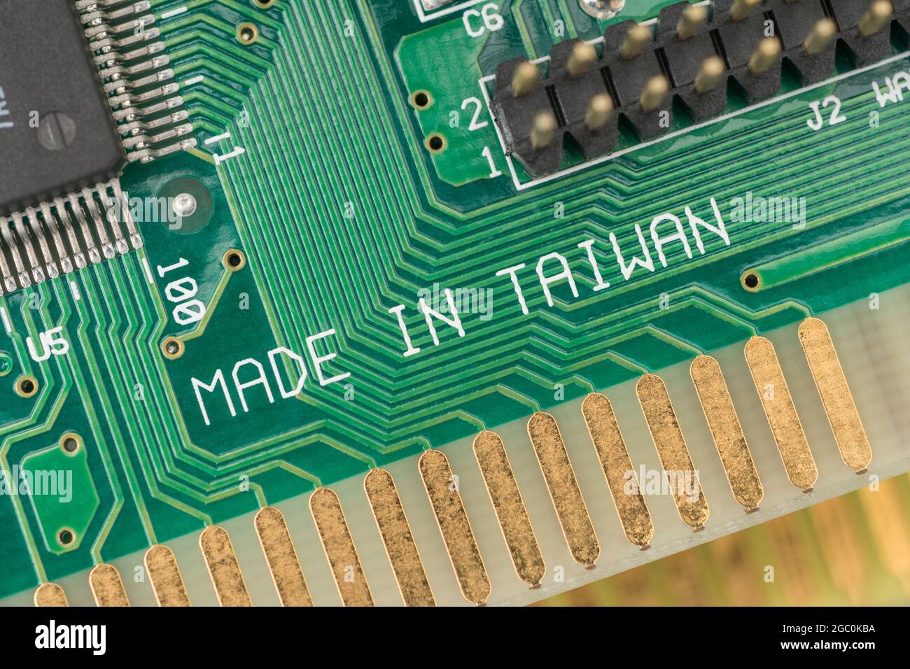 Made in Taiwan printed on the surface of a green pcb circuit board showing traces / connecting wires. For Taiwan electronics industry, foreign trade. Stock Photo