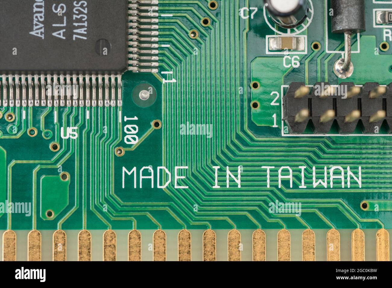 Made in Taiwan printed on the surface of a green pcb circuit board showing traces / connecting wires. For Taiwan electronics industry, foreign trade. Stock Photo