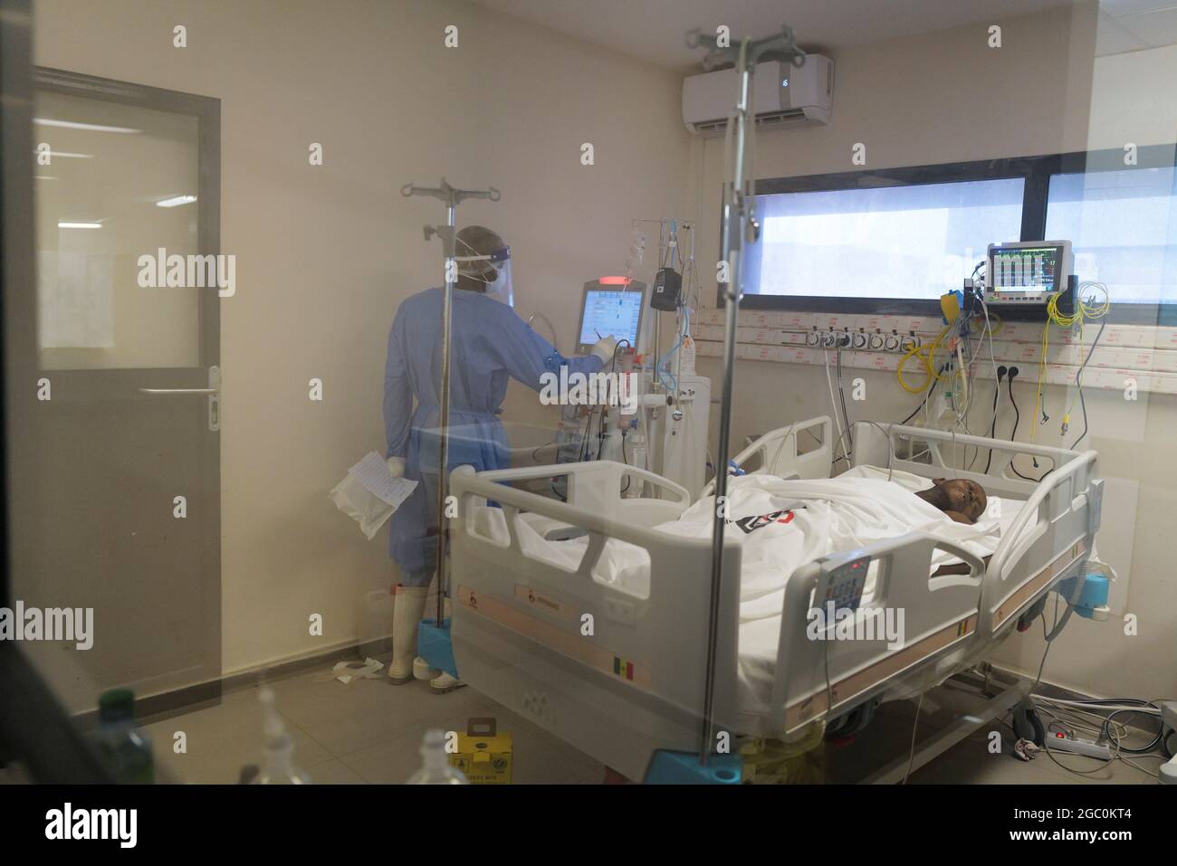 A health worker checks on a patient who is suffering from the coronavirus  disease (COVID-19), in the intensive care unit of the infectious diseases  department of Dalal Jamm hospital, as Senegal records