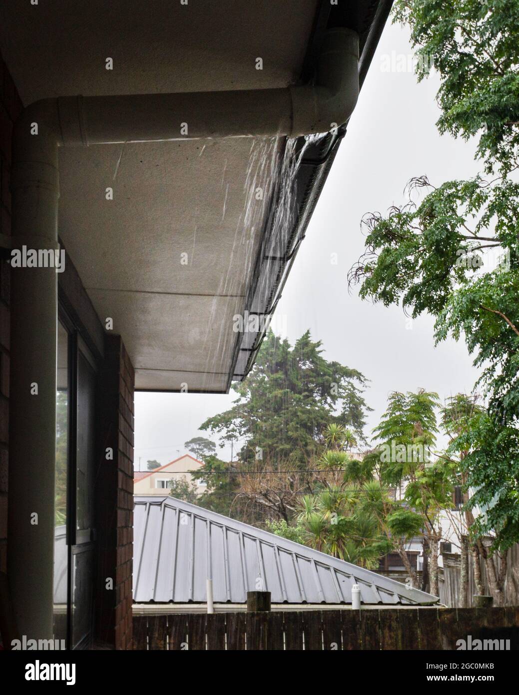 Rainwater overflowing gutters during the heavy rain. Vertical format. Stock Photo