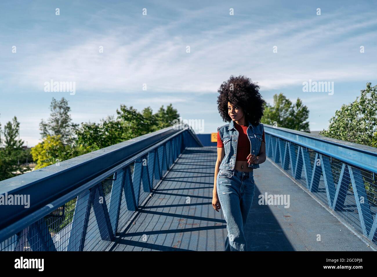 Beautiful woman with afro hair walking in the city and looking to the ...