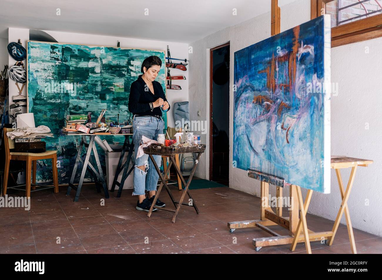 Concentrated Middle Aged Artist Mixing Blue Paint And Using Equipment In Her Home Art Studio Stock Photo Alamy