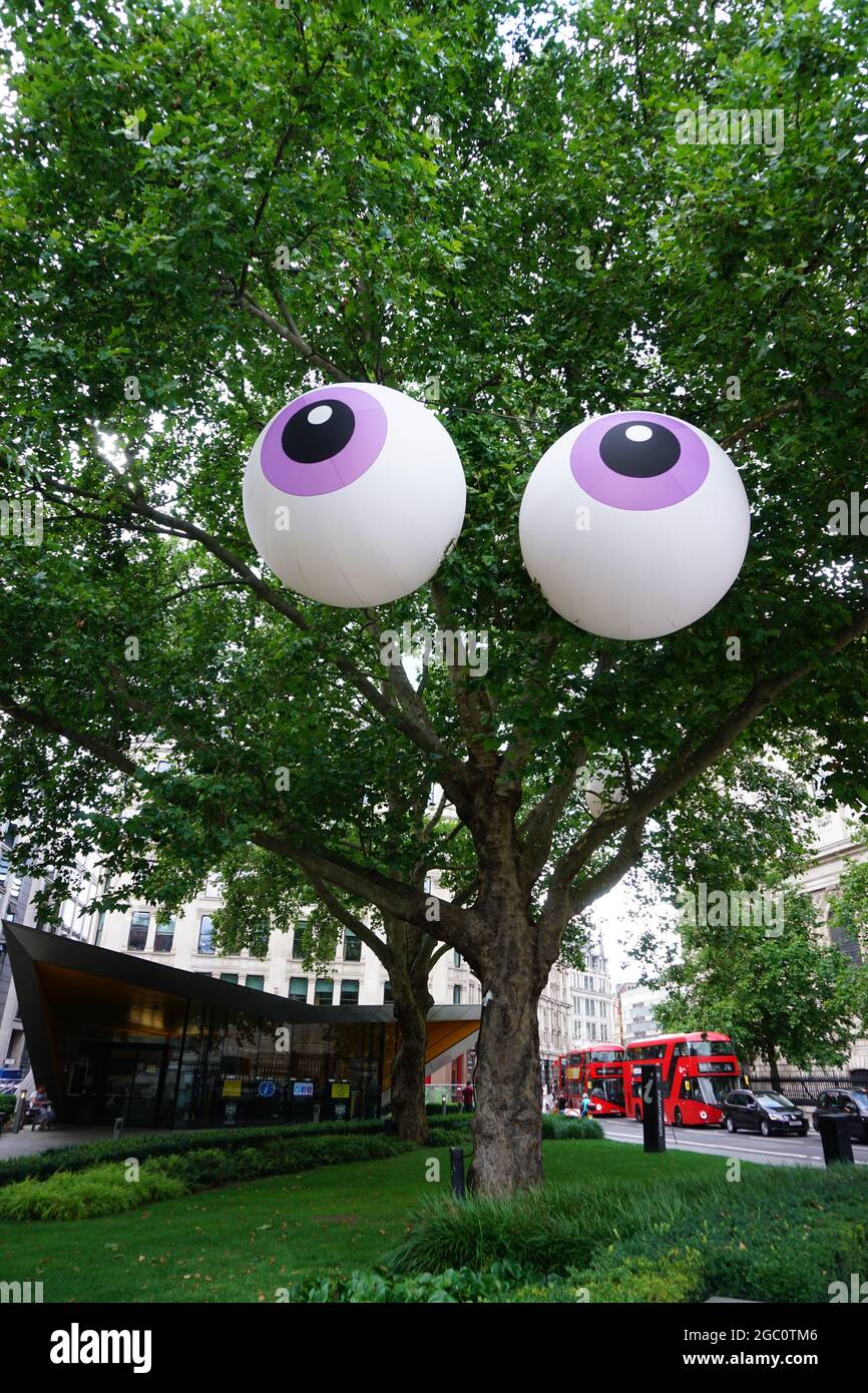 Inflatable eyes in tree in the City of London, United Kingdom Stock Photo