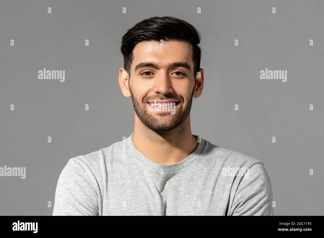 Close up portrait of happy handsome smiling young Caucasian man face with bristles on isolated light gray studio background Stock Photo