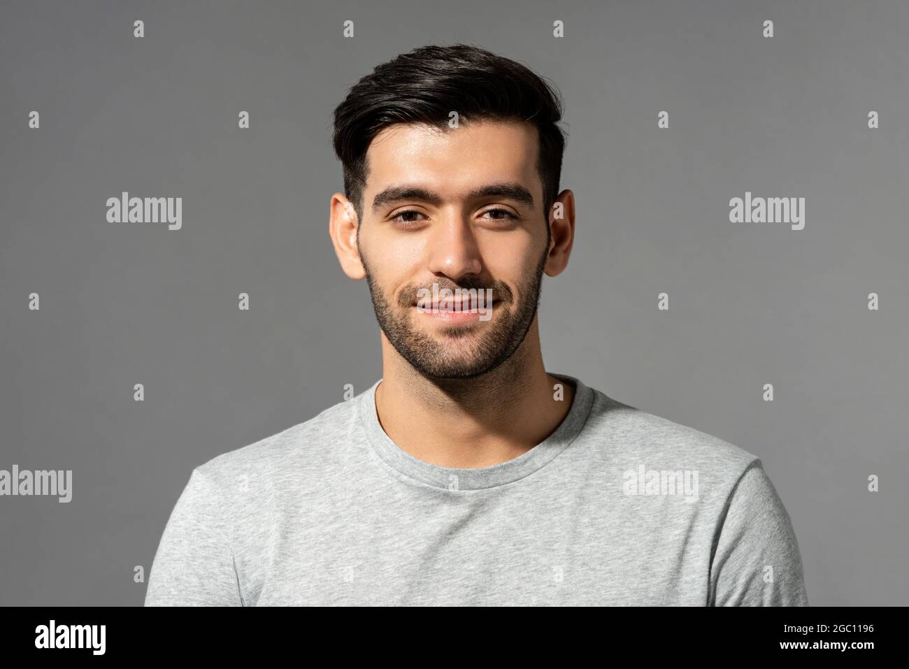 Close up portrait of smiling handsome young Caucasian man face looking at camera on isolated light gray studio background Stock Photo