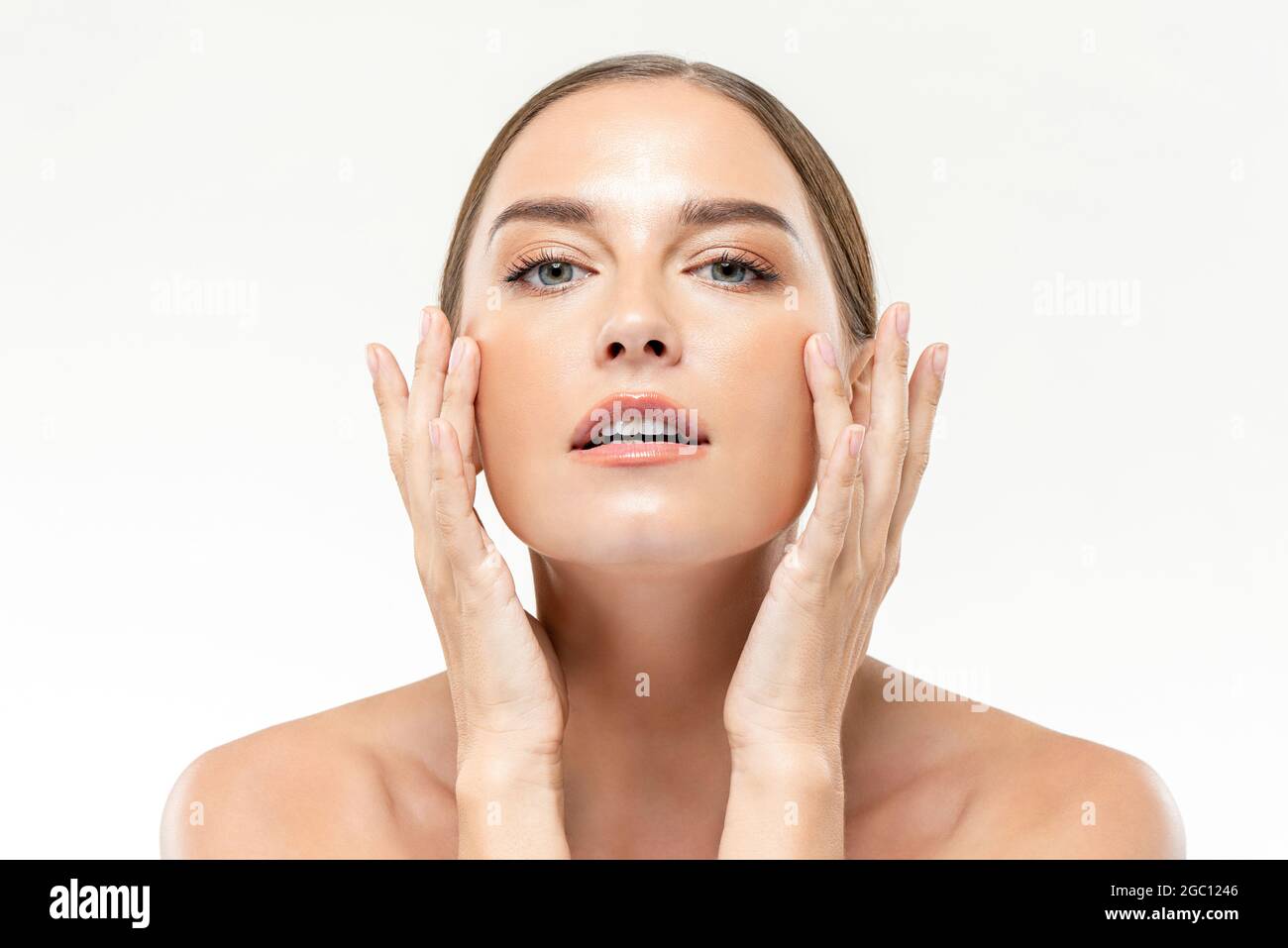 Smooth fresh glowing skin woman touching her face in white isolated studio background for beauty and skincare concepts Stock Photo