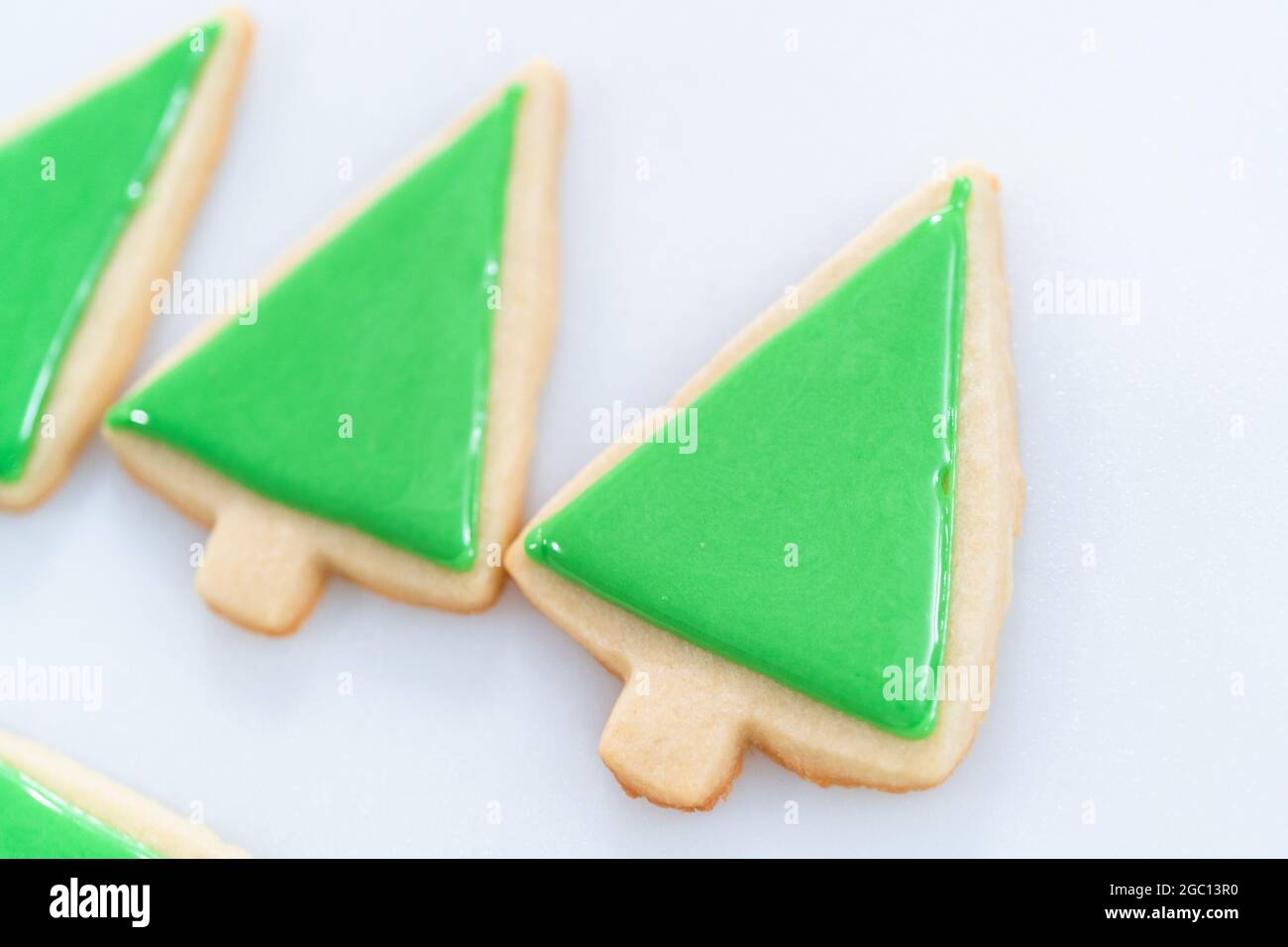 Decorating Christmas sugar cookies with royal icing and sprinkles Stock