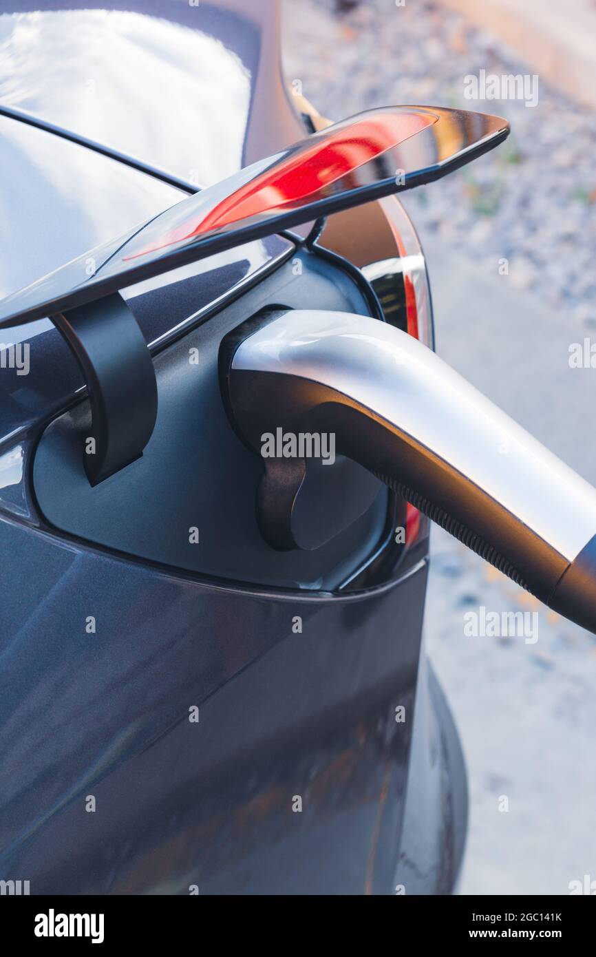 Modern electric vehicle or EV Car plug charging the battery in a power station. Sustainable mobility and Eco-friendly alternative energy concept Stock Photo