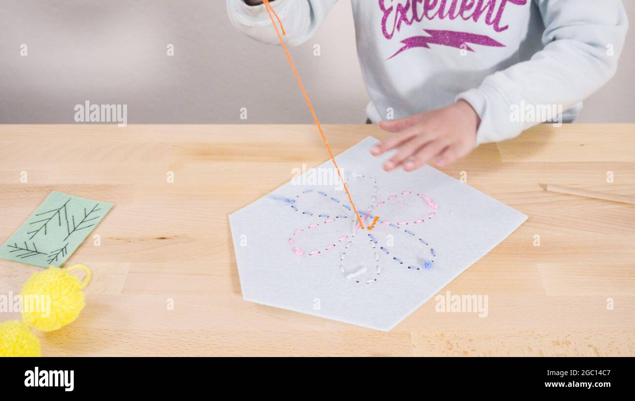 Little girl learning how to sew with sewing craft kit for kids Stock