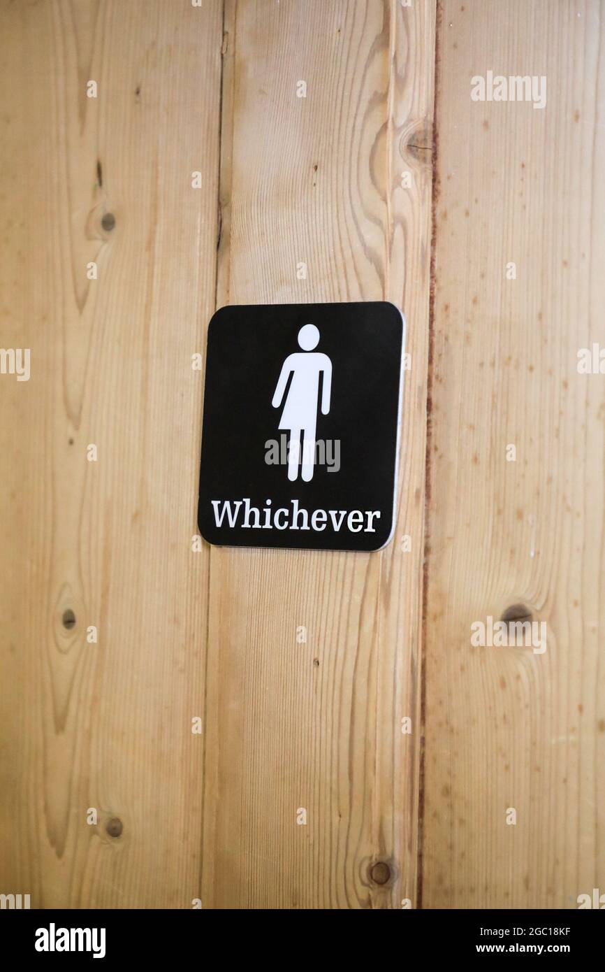 A sign on a unisex toilet door saying 'whichever' with a picture, pictogram or symbol of half a man and half a woman, England, UK Stock Photo
