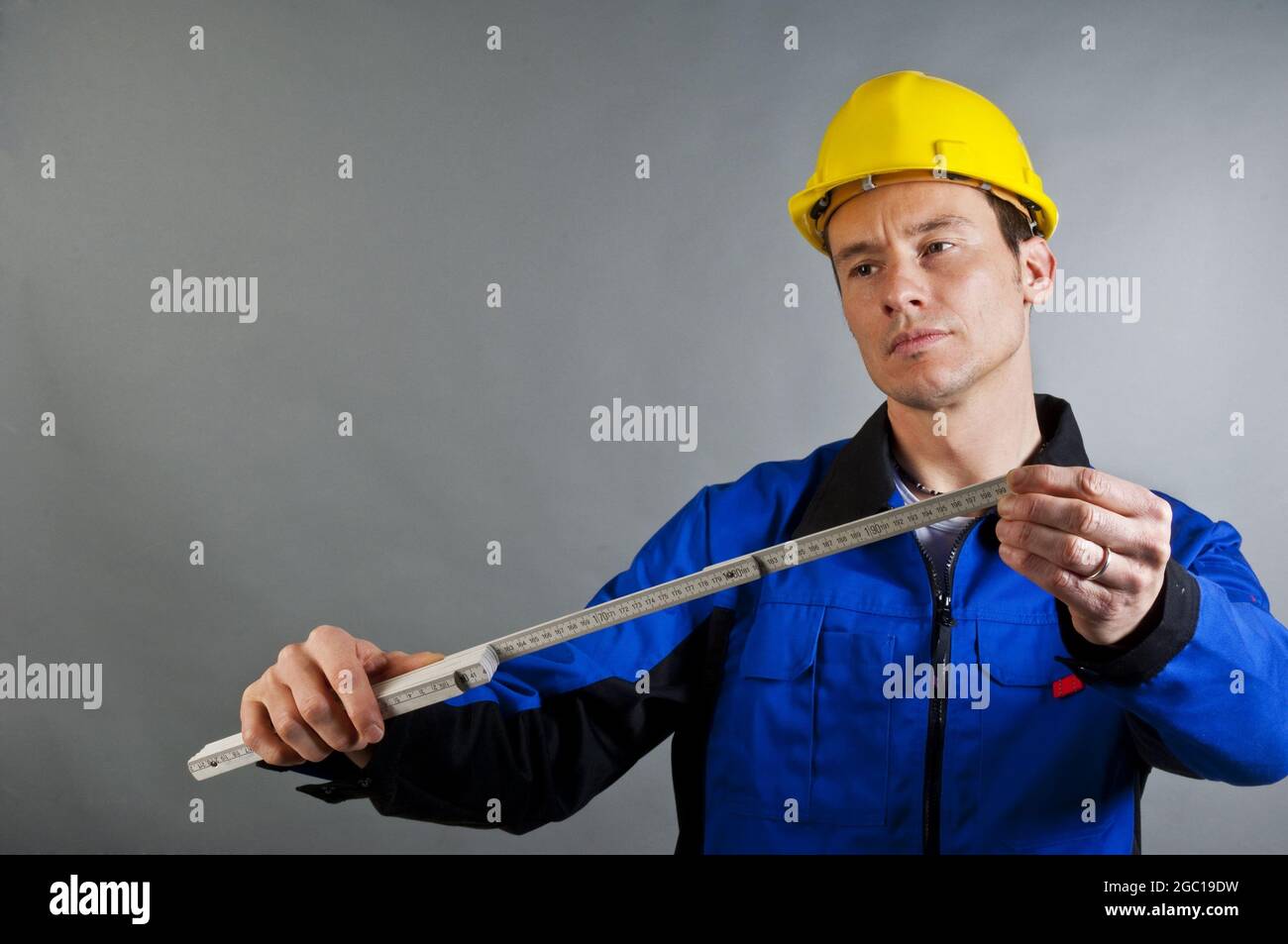 blue collar worker with a folding rule Stock Photo