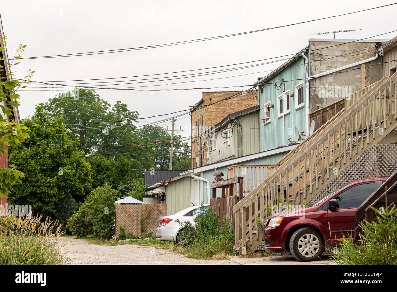 Back laneway and alley of row housing in Ontario, Canada. Cars parked in driveways. Stock Photo