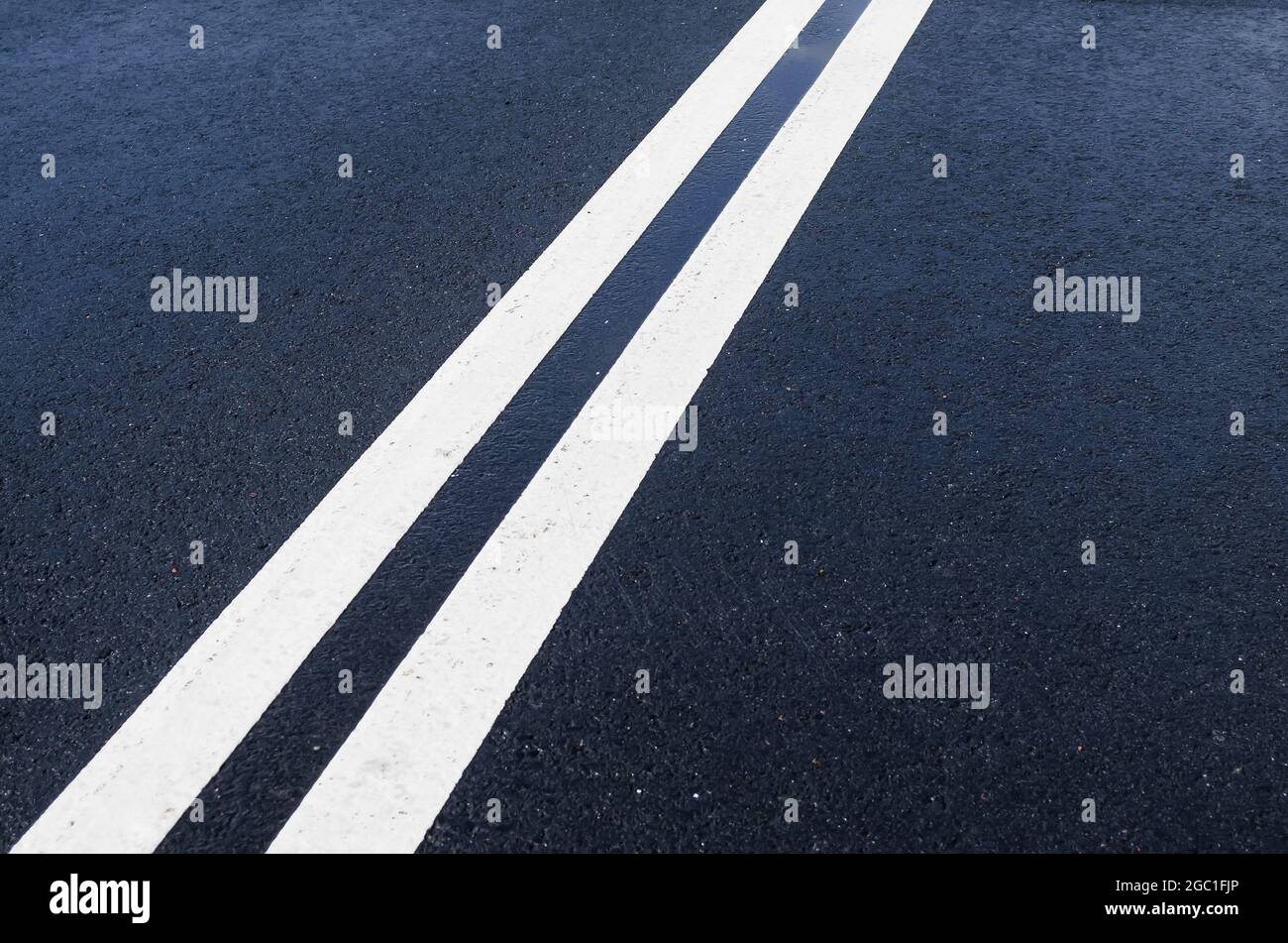 Double solid white line on wet asphalt Stock Photo Alamy