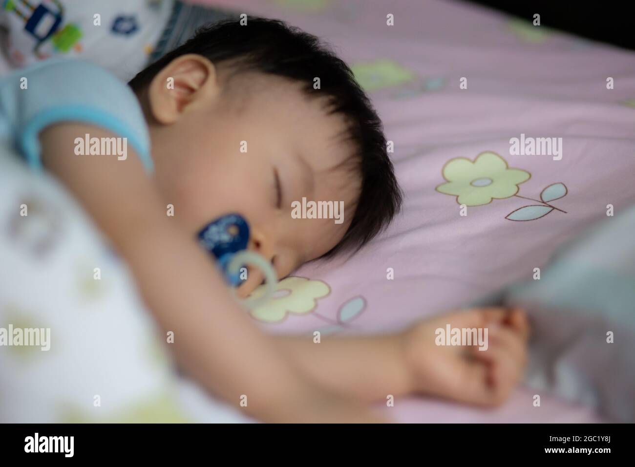 Little Asia Chinese child sleeping on bed with sucking pacifier Stock ...
