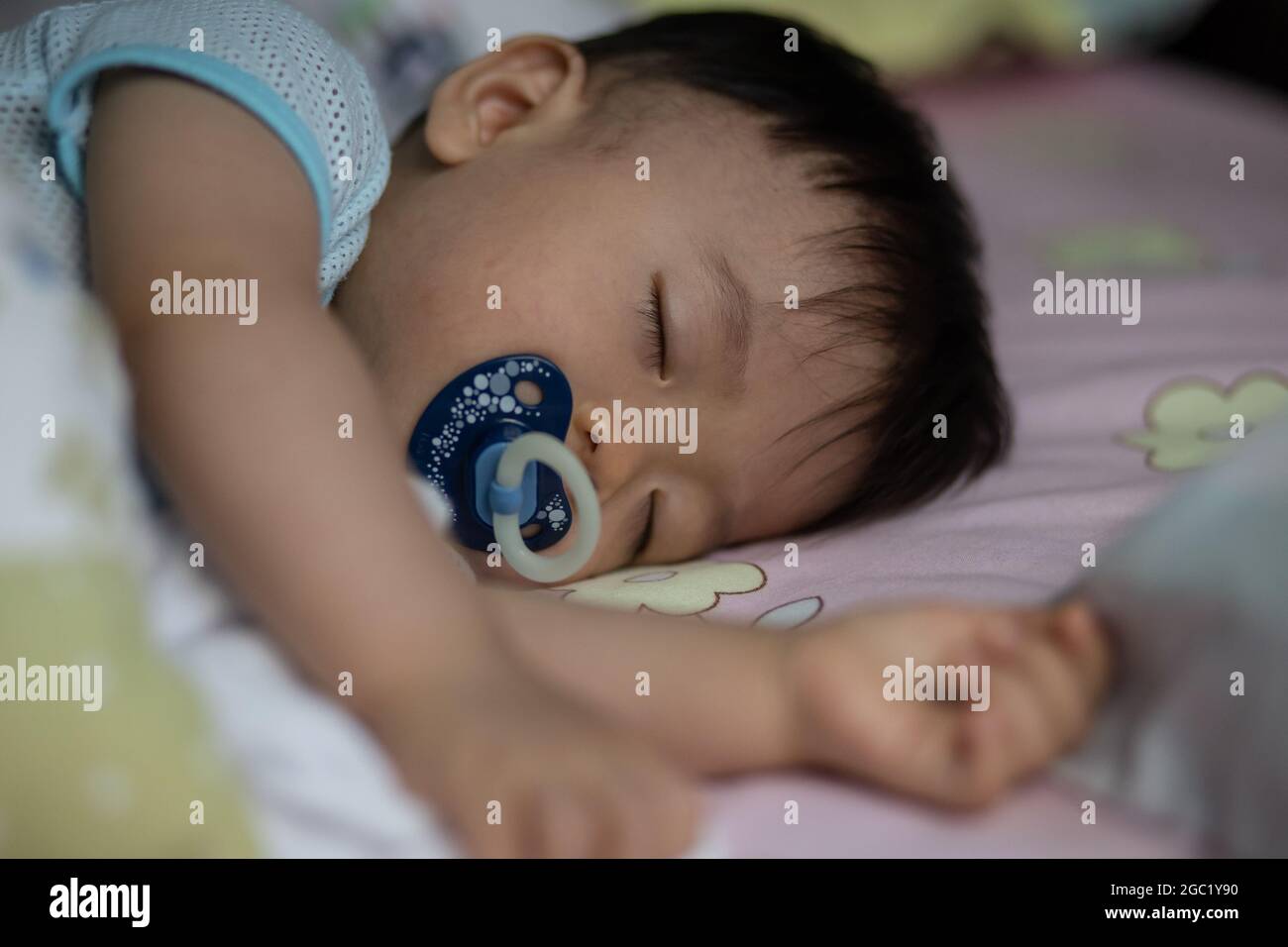Little Asia Chinese child sleeping on bed with sucking pacifier Stock ...