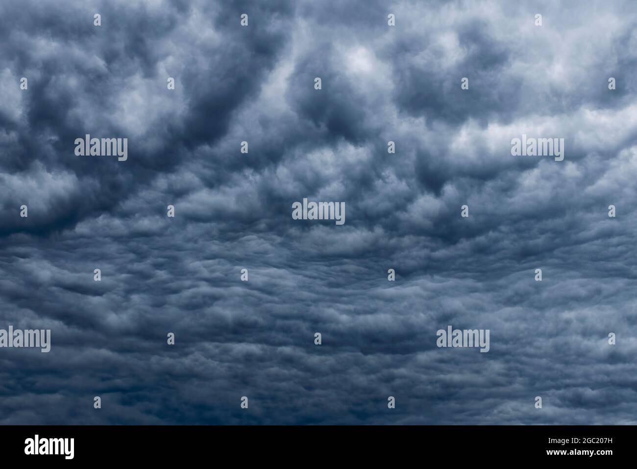 Dark sky, white fluffy and rainy dark clouds before rain. Background texture. Stock Photo