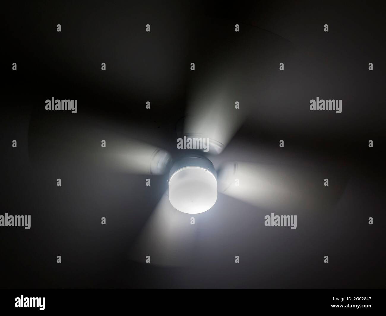 a close up of a fan and light on ceiling Stock Photo