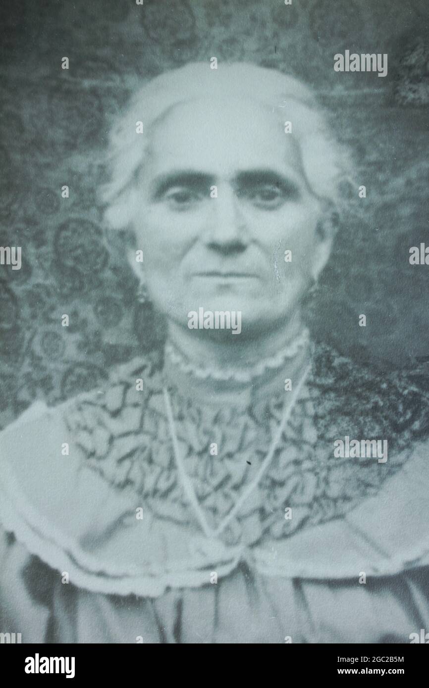 An old photo of a portrait of an elderly woman posing for the camera. Stock Photo