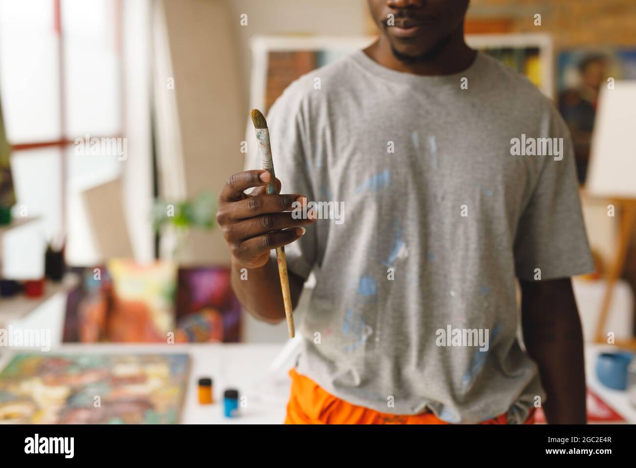 African american male painter at work holding brush in art studio Stock Photo