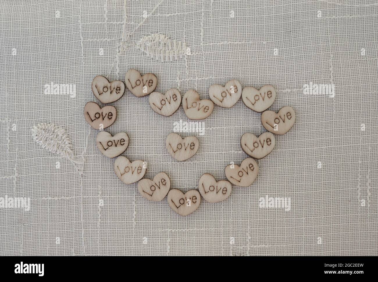 Small wooden love hearts in the shape of a heart. Stock Photo