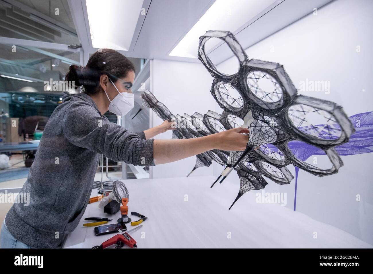 Nuremberg, Germany. 06th Aug, 2021. Model maker Leyla Kyjanek Yunis places the model of her research pavilion 'Elytra Pavilion' on a scale of 1:20 in a display case in the exhibition rooms of the Future Museum, the branch of the Deutsches Museum in Munich. The opening of the museum with almost 3,000 square meters of exhibition space is planned for mid-September 2021. Credit: dpa picture alliance/Alamy Live News Stock Photo