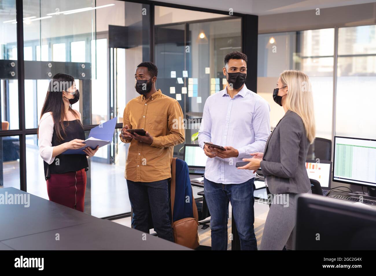 Diverse group of business colleagues wearing face masks and having ...