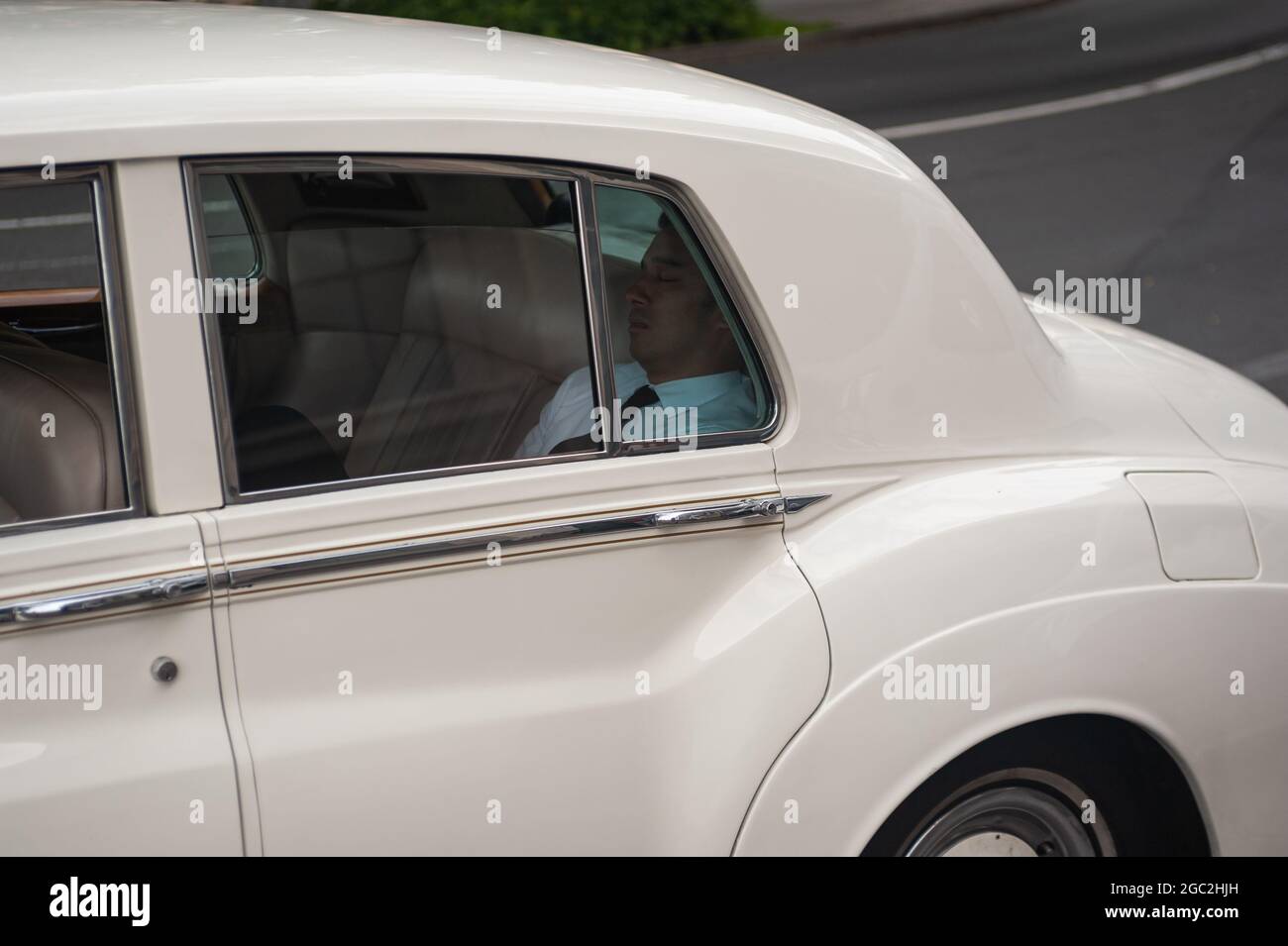 21.09.2019, Sydney, New South Wales, Australia - A man sits in the back seat of a luxury limousine and sleeps. Stock Photo