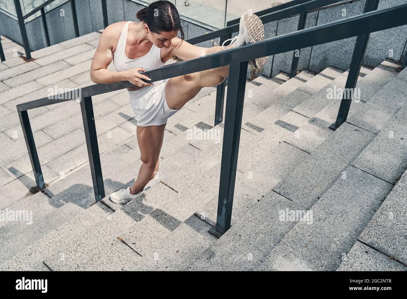 Athletic female doing physical activities on stairs outdoors Stock Photo