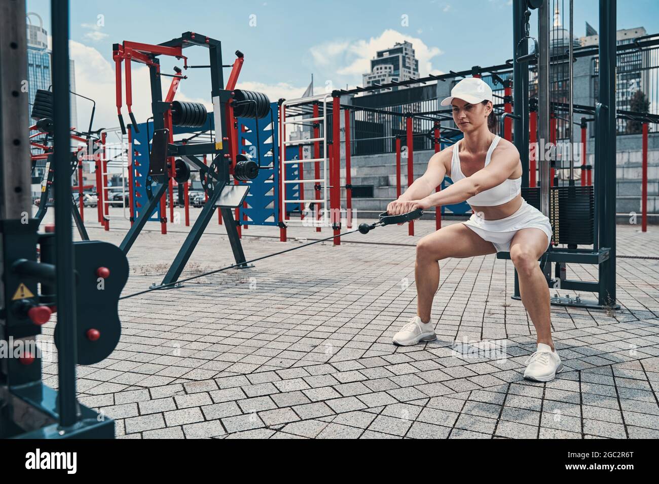 Woman on bent knees pulling rope of cable pulley Stock Photo Alamy