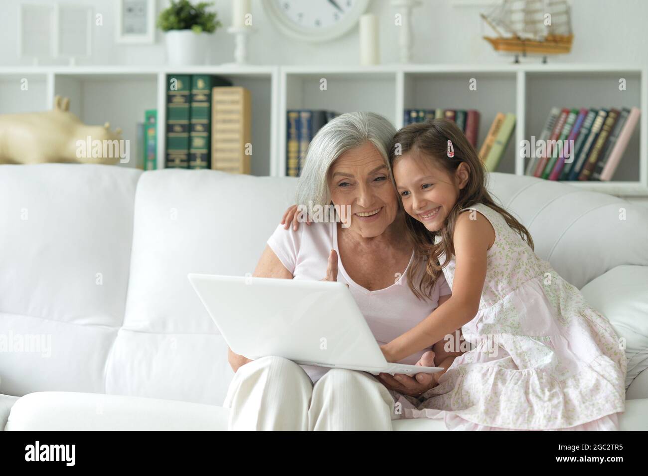 Grandmother and granddaughter using laptop together at home Stock Photo ...