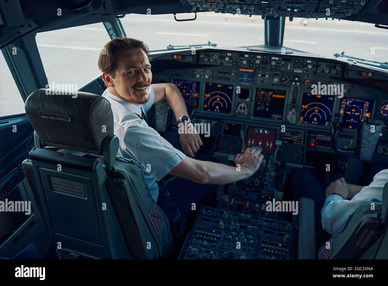 Joyful chief pilot posing for the camera in the cockpit Stock Photo Alamy