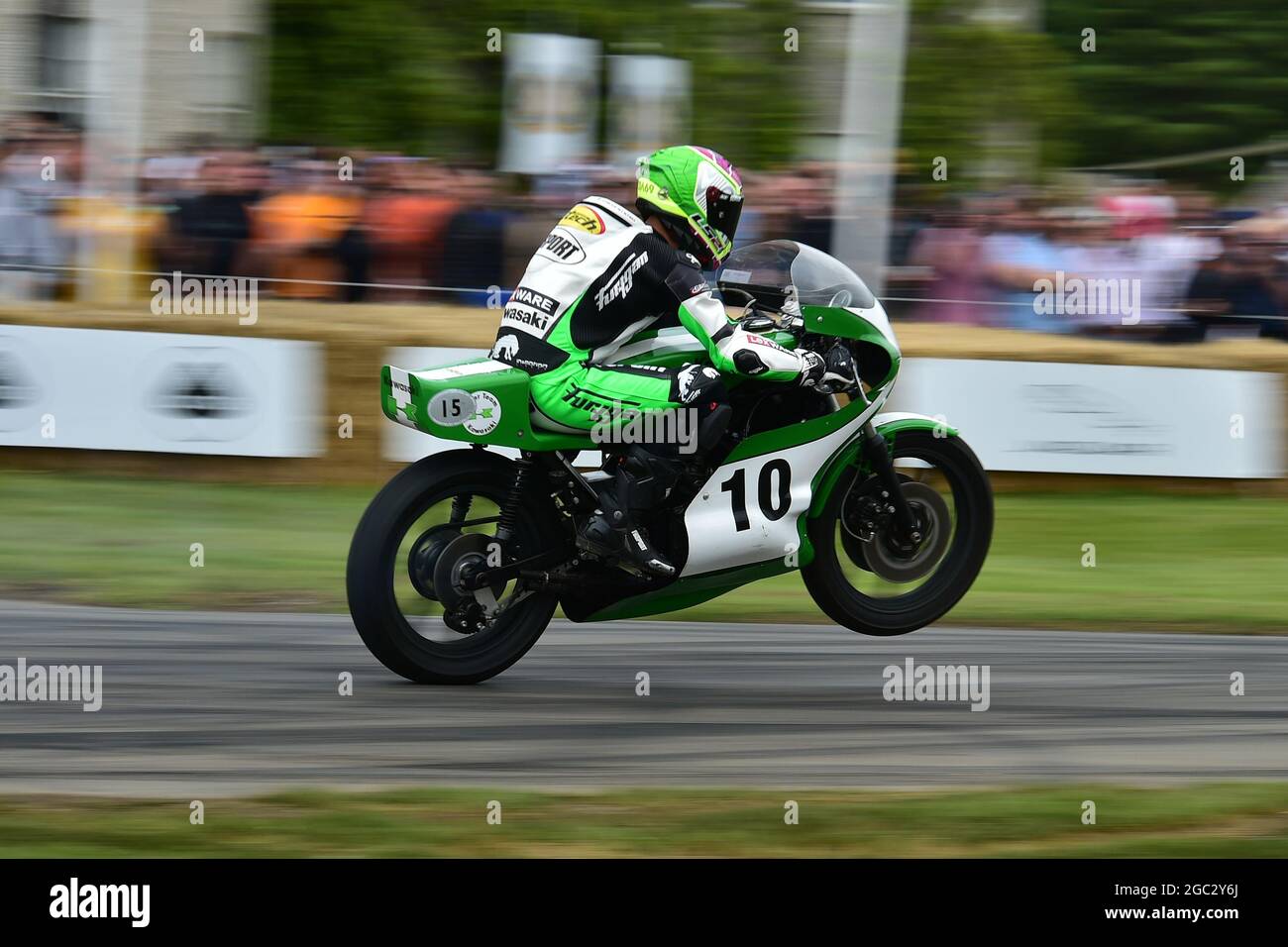 Pulling a wheelie outside Goodwood House, Chris Wilson, Kawasaki KR750, 110 Years of the Mountain Course, The Maestros - Motorsport's Great All-Rounde Stock Photo