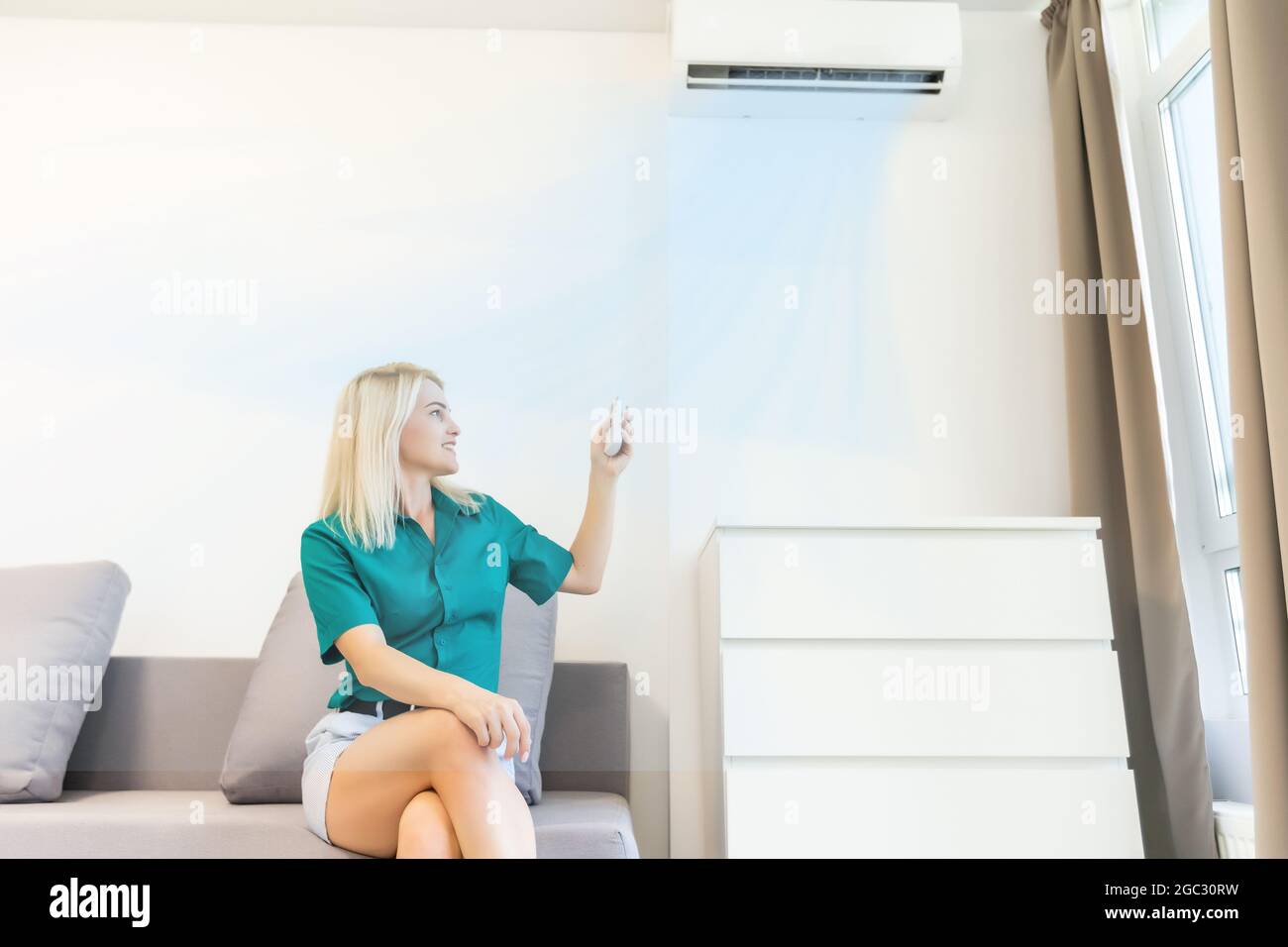 Women enjoy the coolness while standing in front of the air conditioner ...