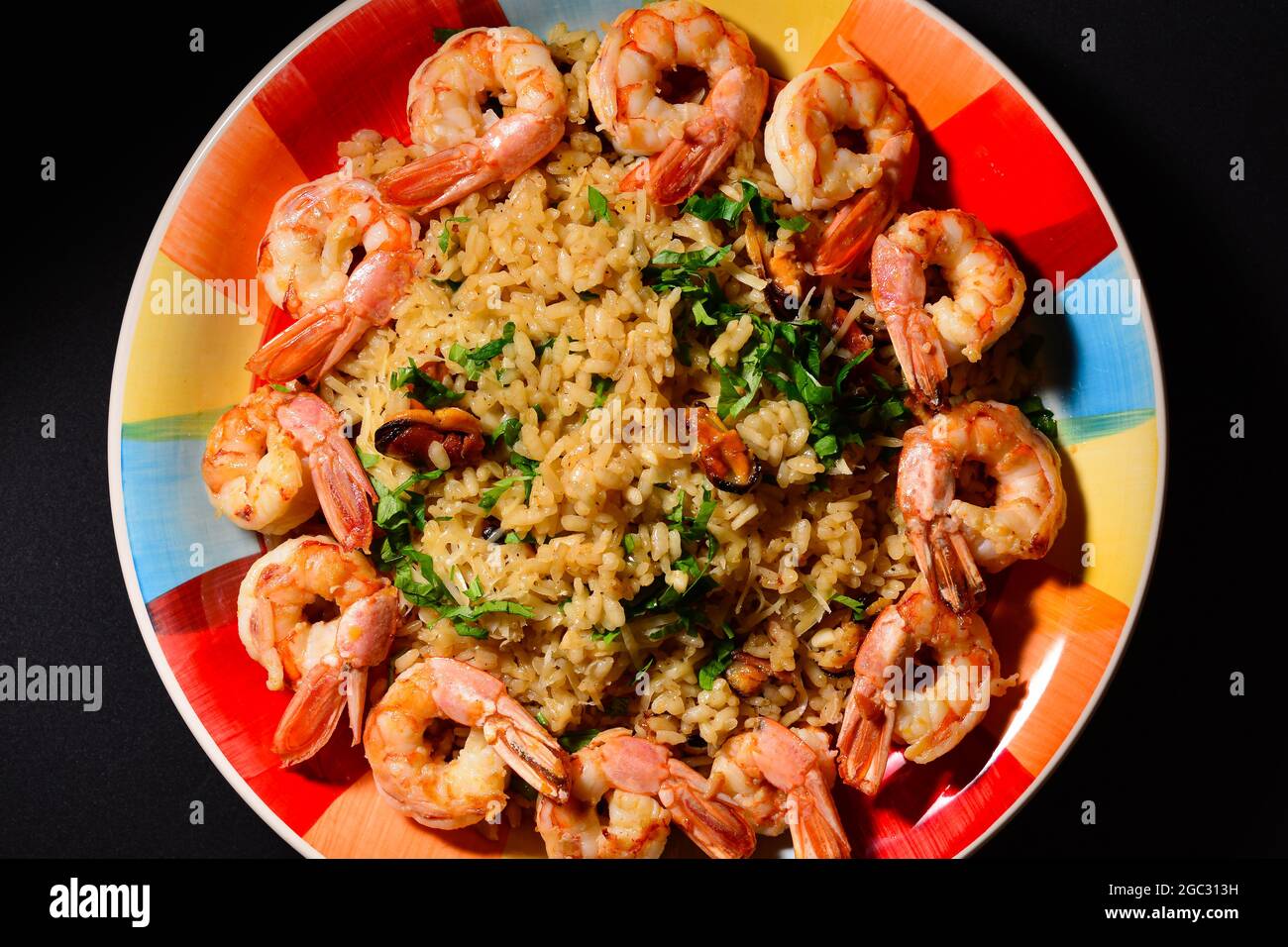 Risotto with mussels and shrimps on a colorful beautiful plate Stock