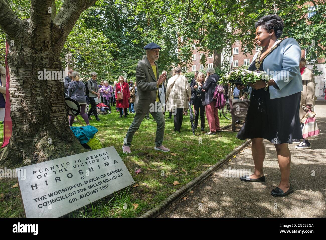 London, UK. 6th August 2021. Sabrina Francis, Mayor of Camden lays a wreath at the Hiroshima Cherry Tree. 76 years after atomic bombs were dropped on Hiroshima and Nagaski, London CND met in Tavistock Square to remember the many killed and survivors who are still suffering the event, and to celebrate the UN treaty prohibiting nuclear weapons which came into force this January. They called on the government to end the UK's nuclear weapon programme. Peter Marshall/Alamy Live News Stock Photo