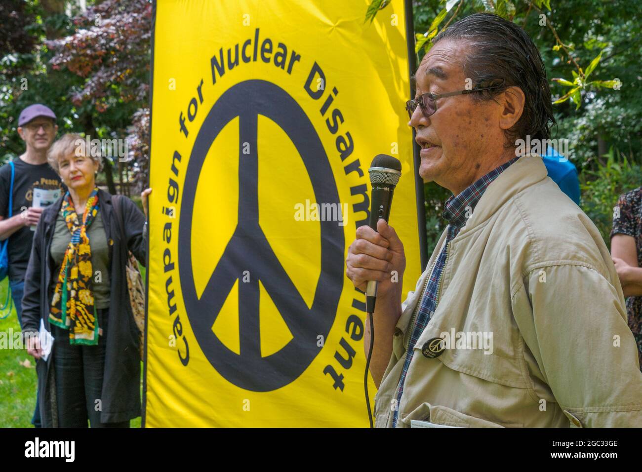 London, UK. 6th August 2021. A Japanese nuclear protester speaks. 76 years after atomic bombs were dropped on Hiroshima and Nagaski, London CND met at the Hiroshima Cherry tree in Tavistock Square to remember the many killed and survivors who are still suffering the event, and to celebrate the UN treaty prohibiting nuclear weapons which came into force this January. They called on the government to end the UK's nuclear weapon programme. Peter Marshall/Alamy Live News Stock Photo