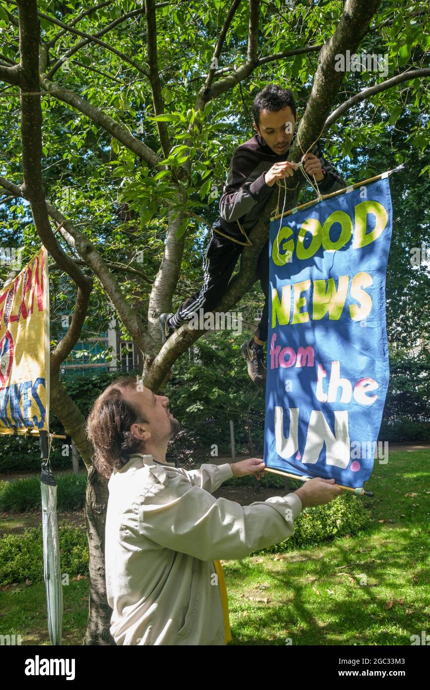 London, UK. 6th August 2021. A banner celebrates the UN Treaty prohibiting Nuclear Weapons. 76 years after atomic bombs were dropped on Hiroshima and Nagaski, London CND met at the Hiroshima Cherry tree in Tavistock Square to remember the many killed and survivors who are still suffering the event, and to celebrate the UN treaty which came into force this January. They called on the government to end the UK's nuclear weapon programme. Peter Marshall/Alamy Live News Stock Photo