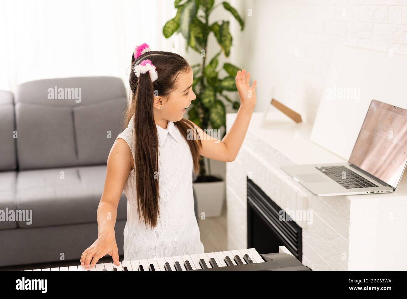 Little girl watching online lesson tutorial how to learn a synthesizer