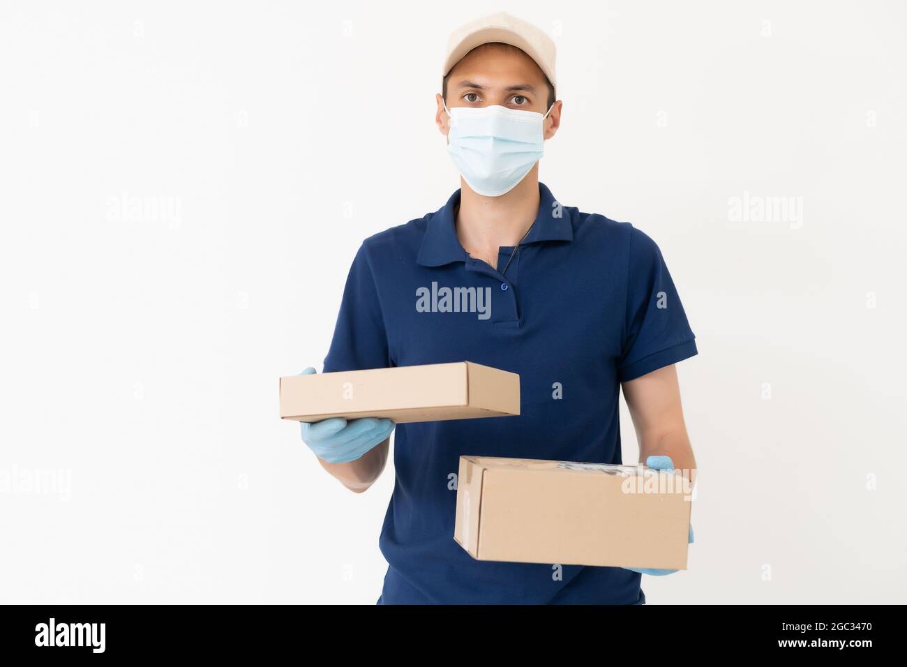 Man from delivery service in t-shirt, in protective mask and gloves ...