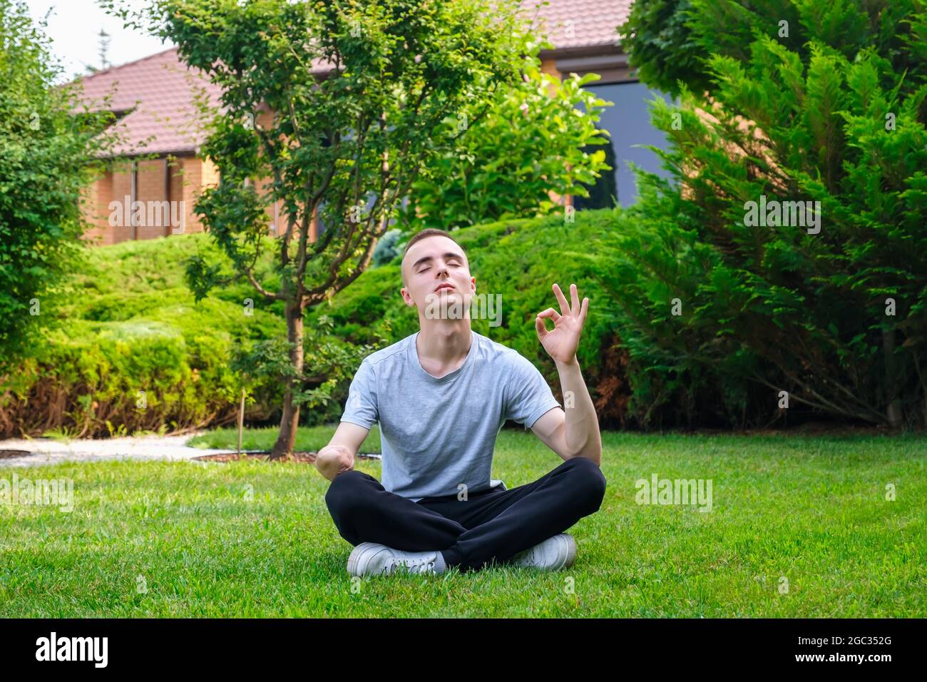 Man with amputated arm exercising with rubber elastic band outdoors Stock Photo