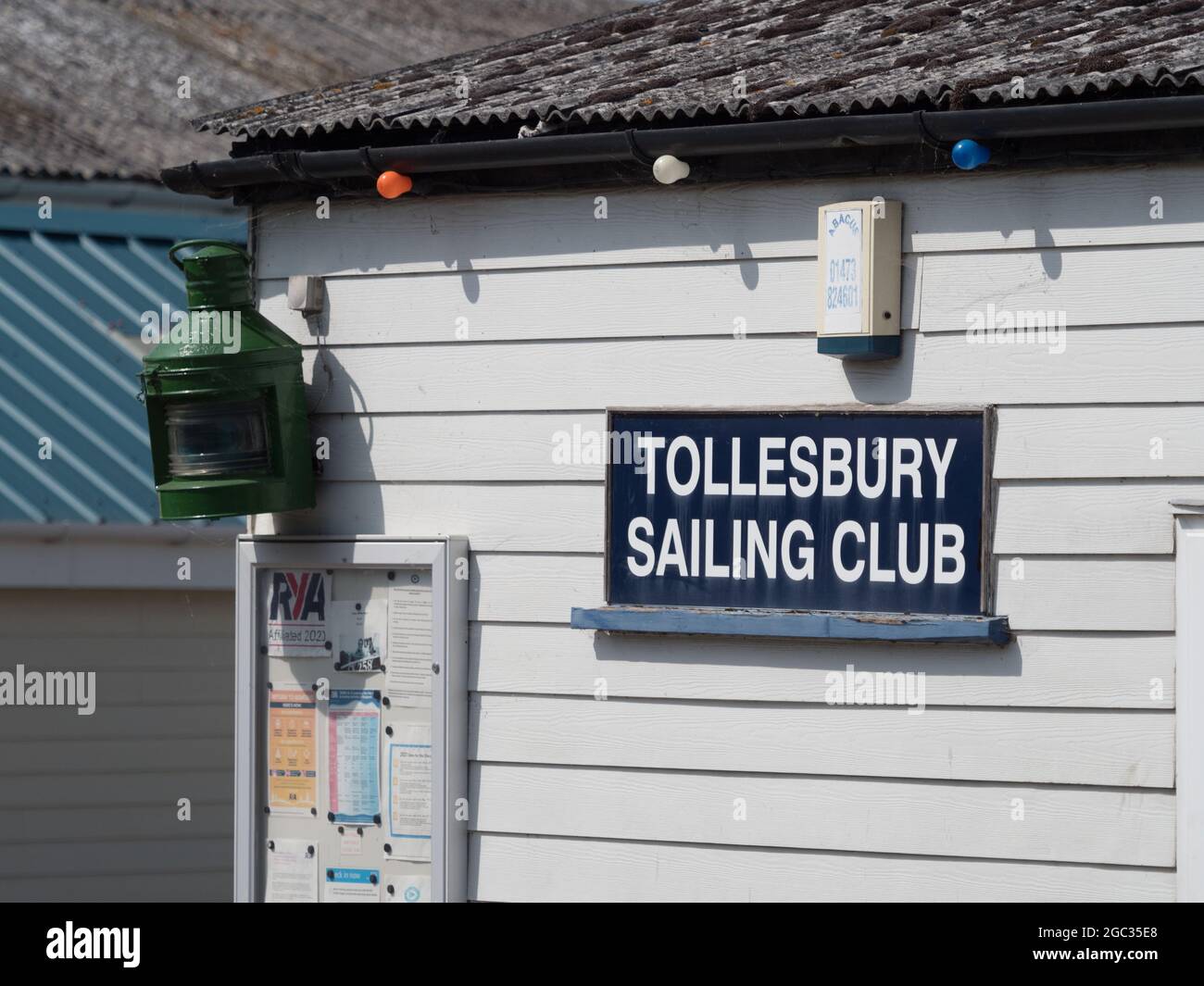 Tollesbury Sailing Club sign on side of white weather boarded building.White lettering on dark blue background Stock Photo