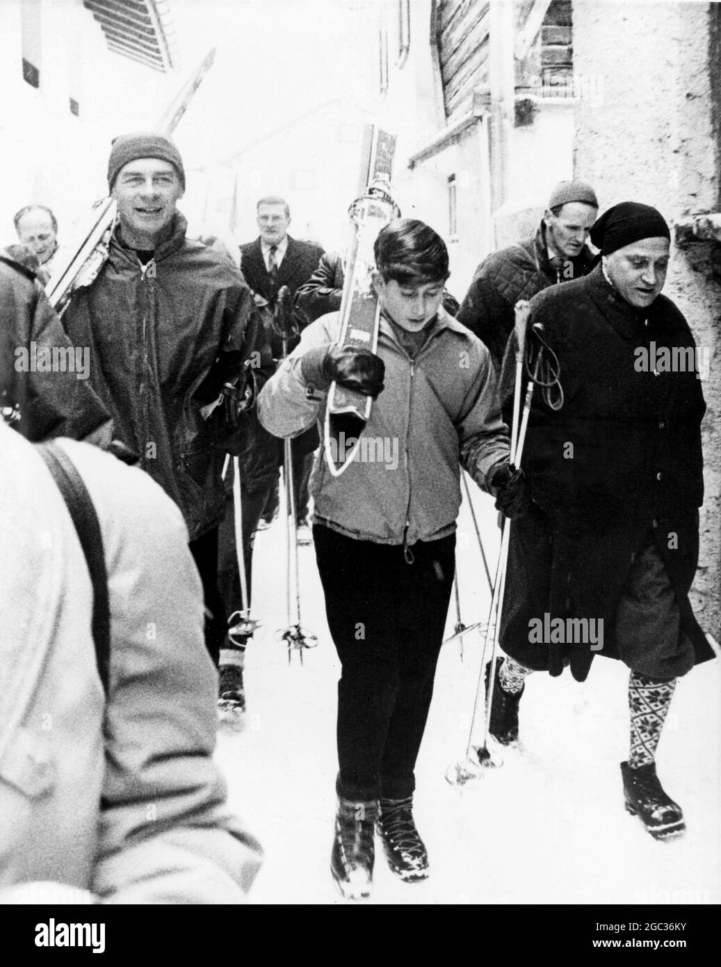 Prince Charles holding his skis over his shoulder goes to his first ...