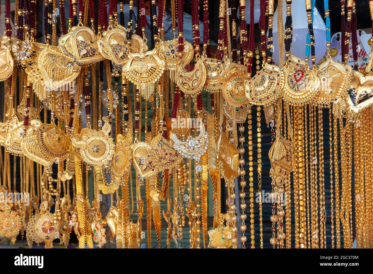 Auspicious gold plated neck pieces are hanging for sale to Indian Bengali women, at Kalighat, Kolkata , West Bengal, India. In Hinduism, gold symboliz Stock Photo