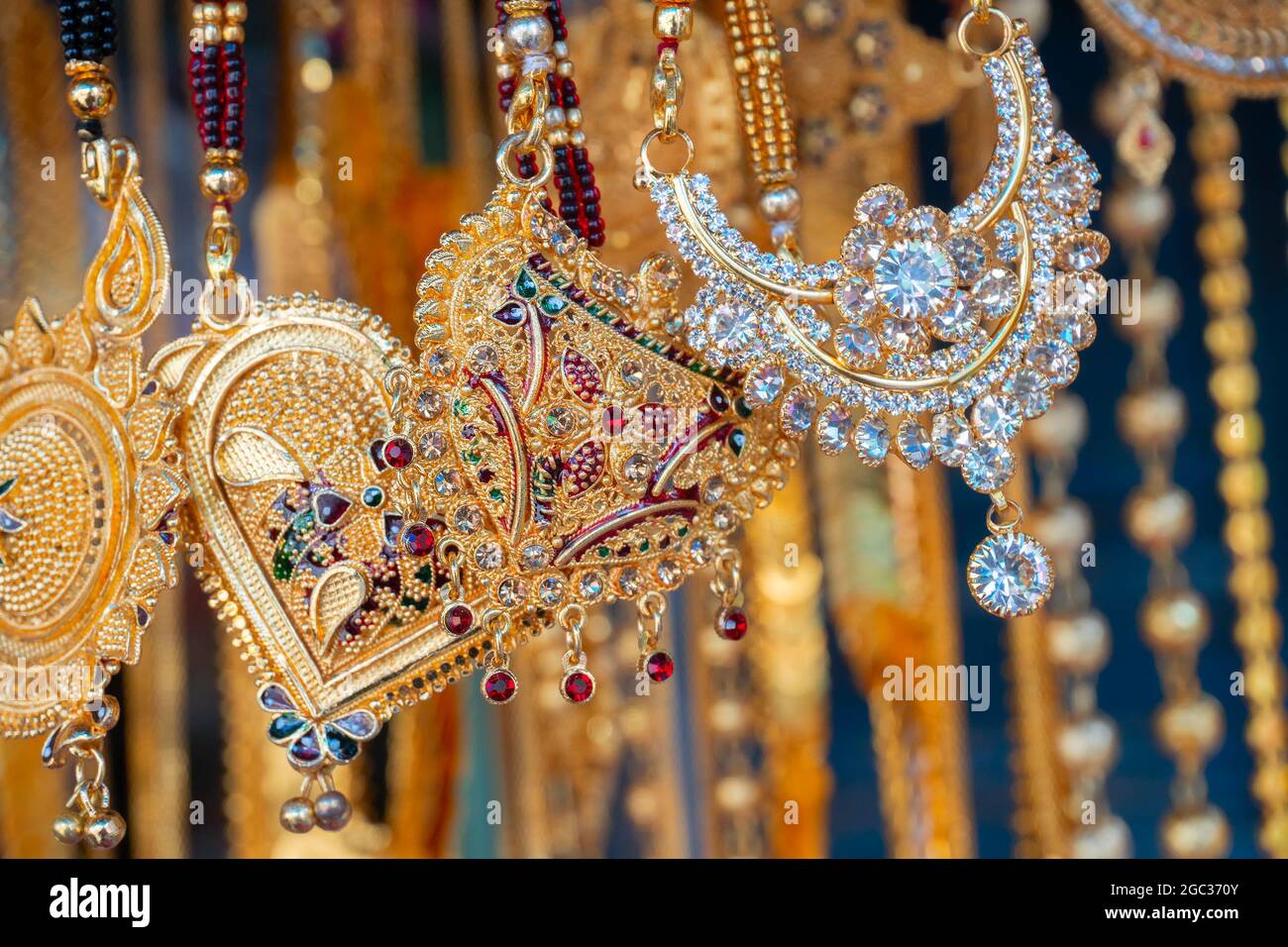 Auspicious gold plated neck pieces are hanging for sale to Indian Bengali women, at Kalighat, Kolkata , West Bengal, India. In Hinduism, gold symboliz Stock Photo