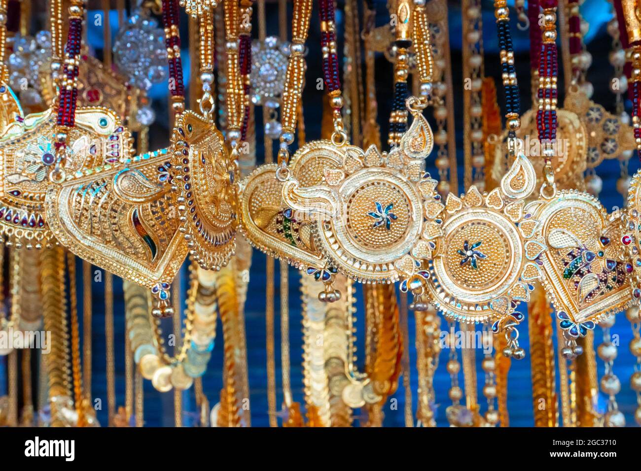 Auspicious gold plated neck pieces are hanging for sale to Indian Bengali women, at Kalighat, Kolkata , West Bengal, India. In Hinduism, gold symboliz Stock Photo