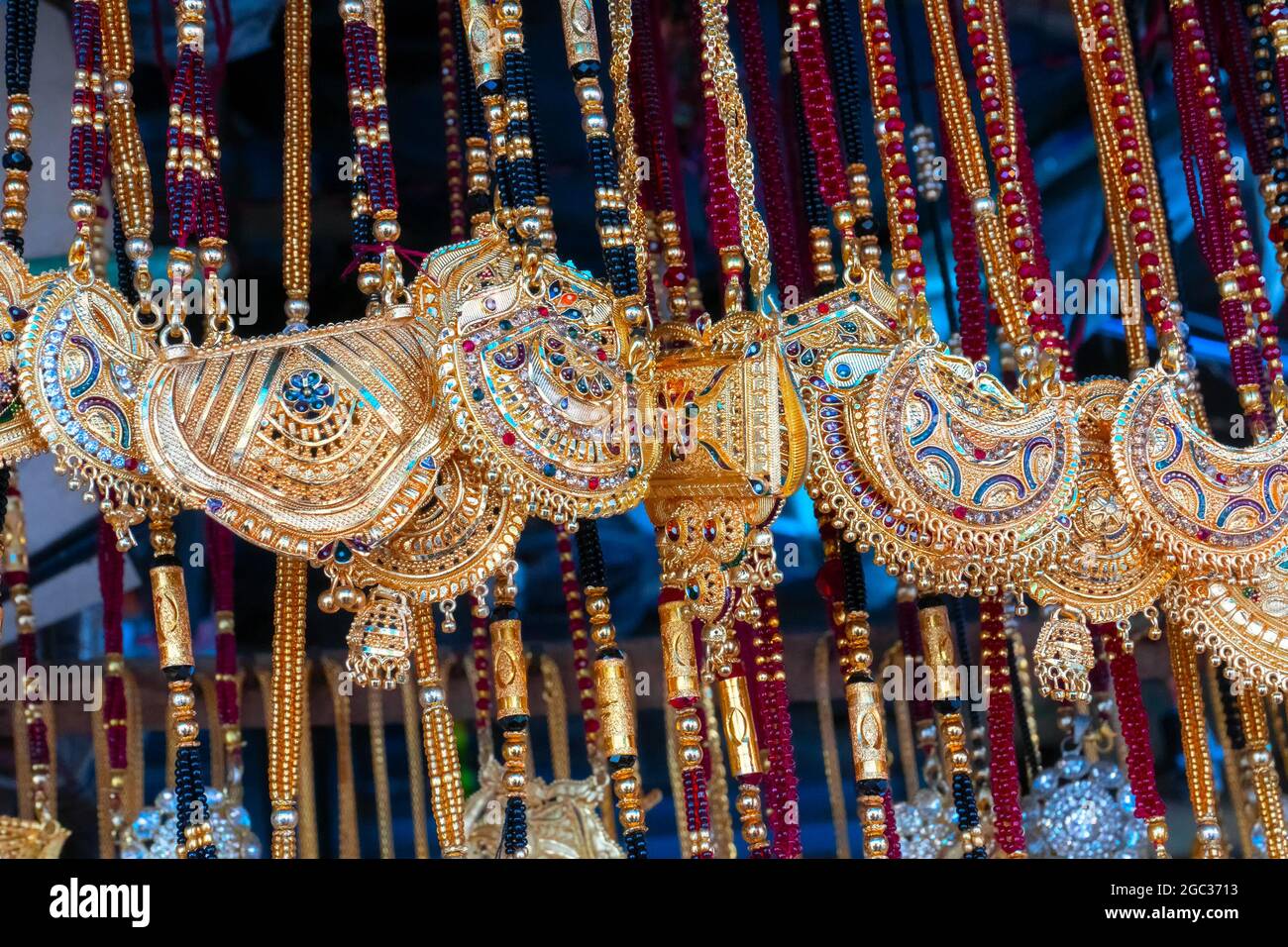 Auspicious gold plated neck pieces are hanging for sale to Indian Bengali women, at Kalighat, Kolkata , West Bengal, India. In Hinduism, gold symboliz Stock Photo